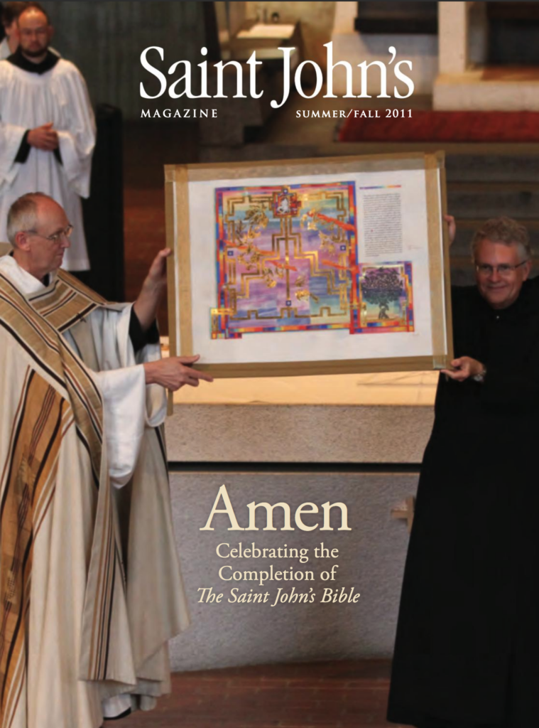 Two men, one in religious robes, hold up a colorful illuminated manuscript on a stage. The cover text reads "Saint John's Magazine, Summer/Fall 2011" and "Amen: Celebrating the Completion of The Saint John's Bible.